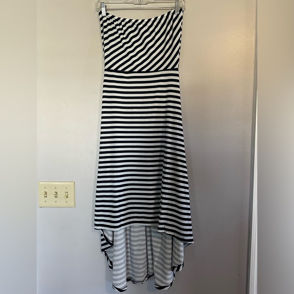 Sleeveless sundress with a longer back skirt.